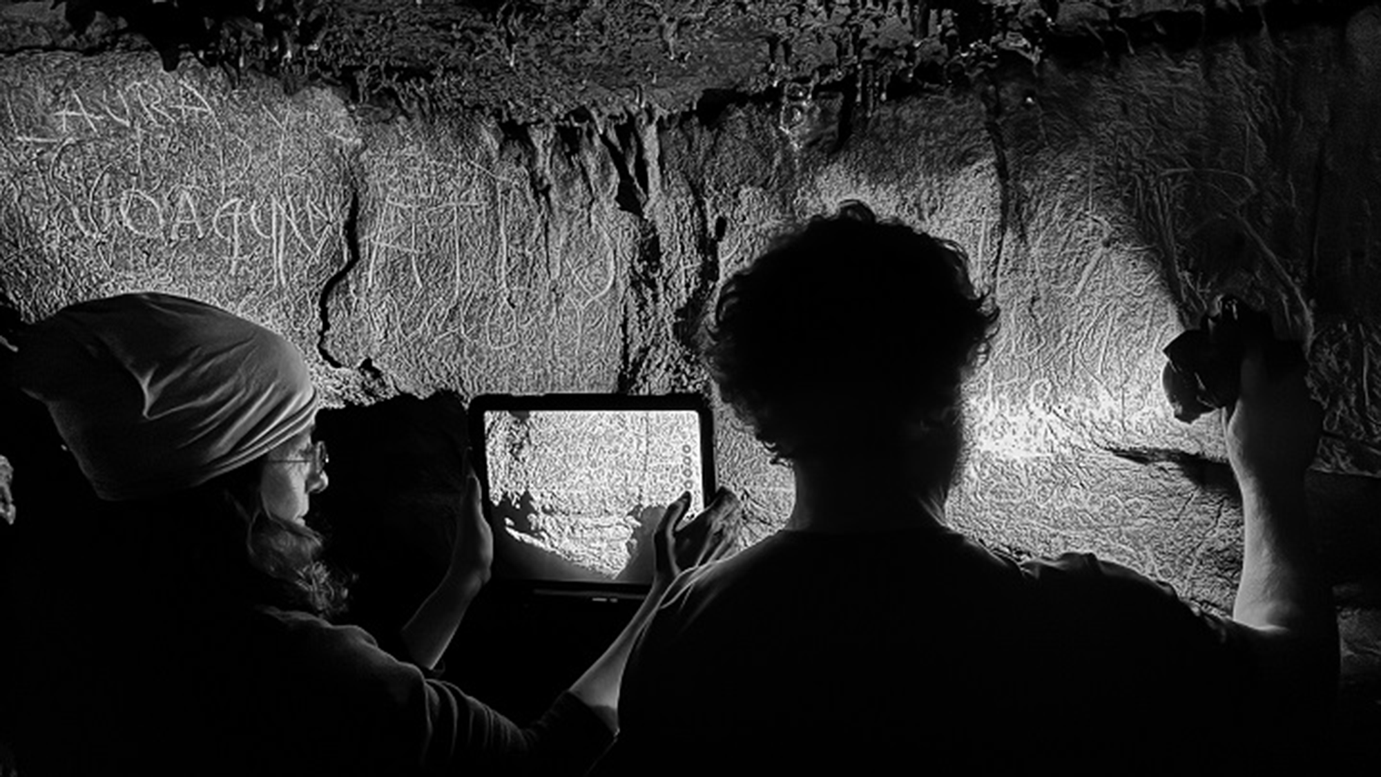 A black and white photo of photographers in a cave