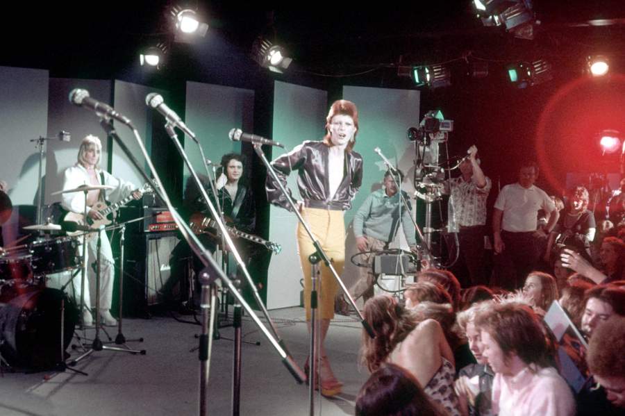 Musician David Bowie performs with his band including Mick Ronson on guitar (in the background on left) in 1973