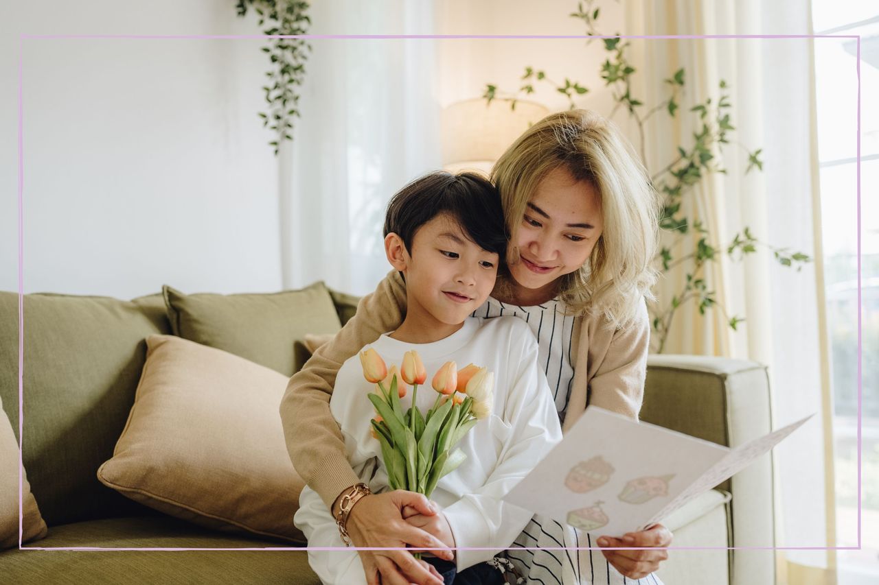 A woman hugging a young boy who is holding flowers and a card