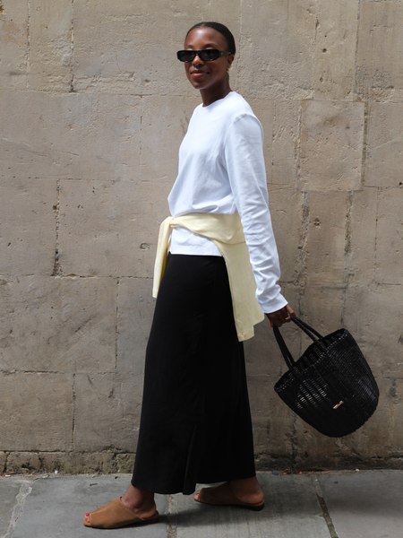 Influencer Taffy Msipa wearing a long sleeve t-shirt, satin skirt and suede mules. 