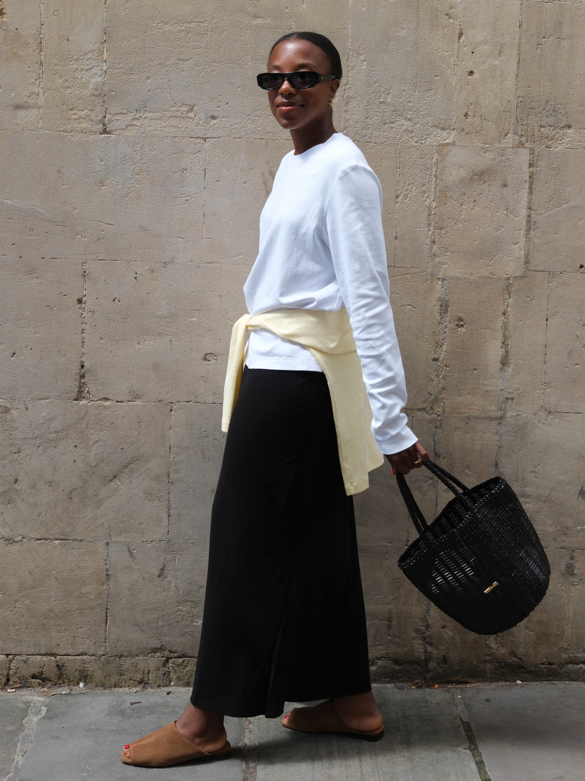 Influencer Taffy Msipa wearing a long sleeve t-shirt, satin skirt and suede mules. 