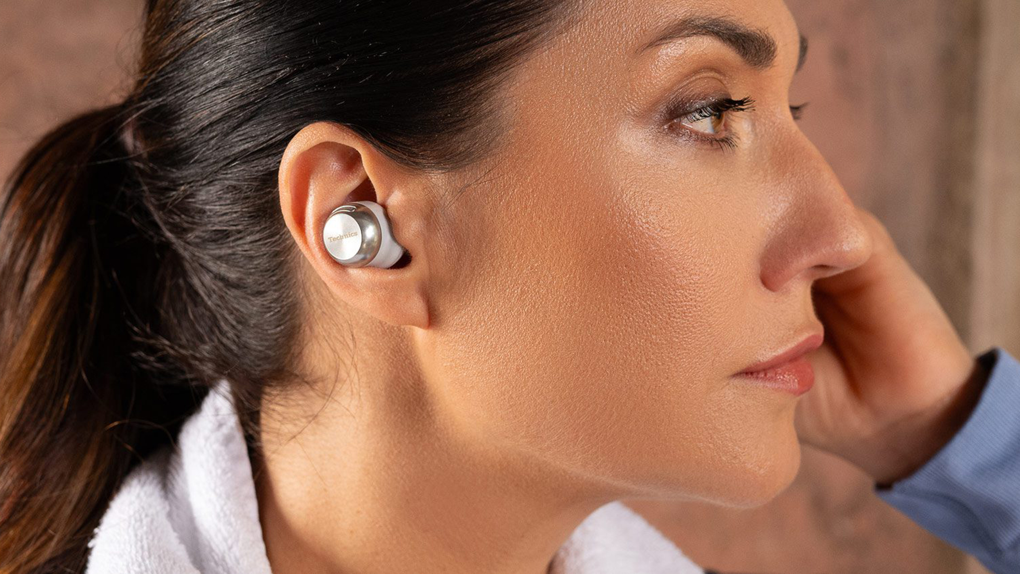 Woman wearing Technics EAH-AZ100 earbuds.