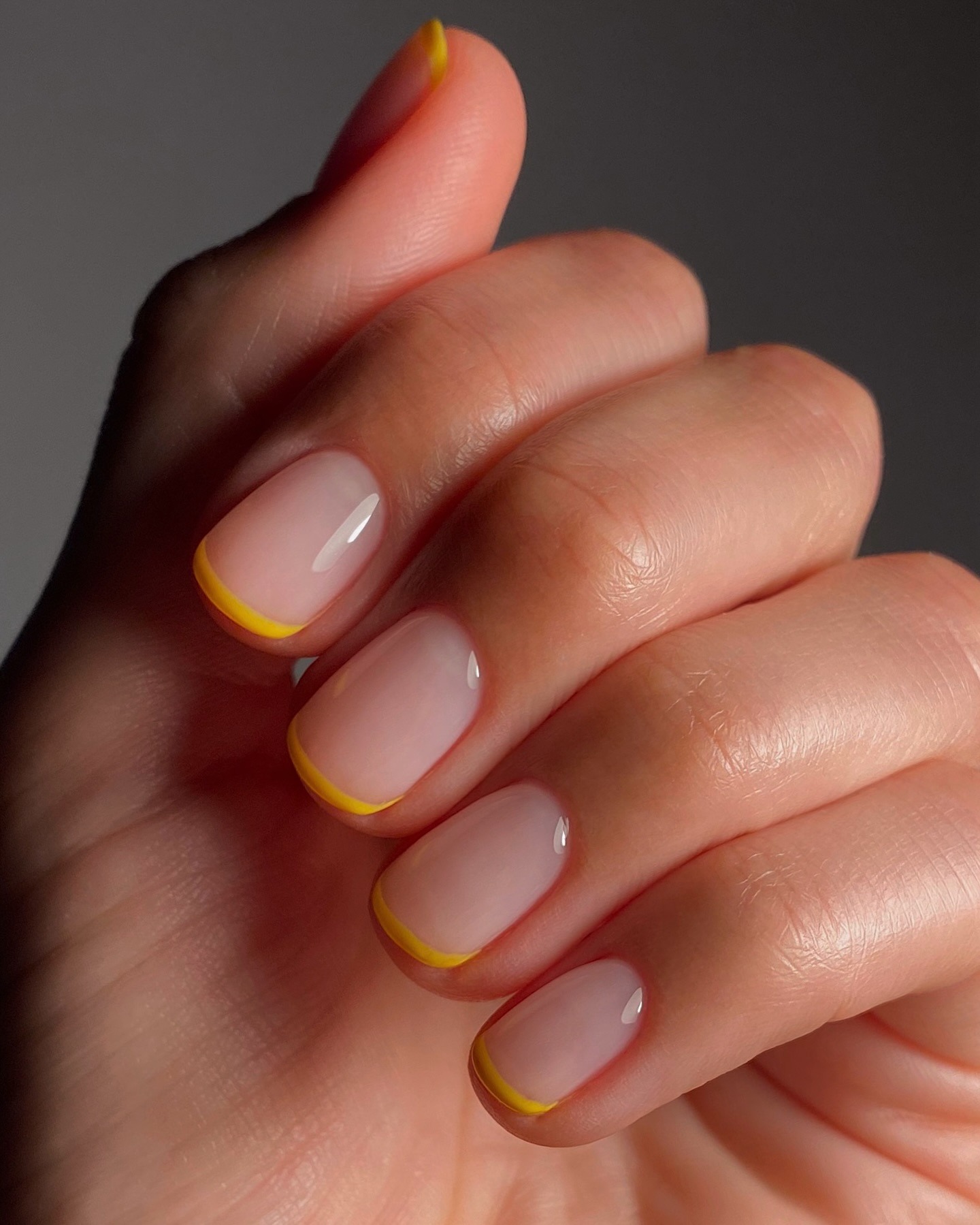 A clear manicure with warm yellow French tips
