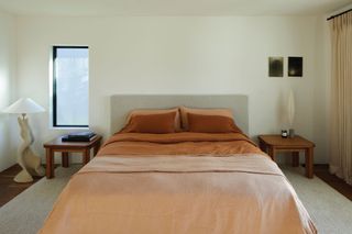 minimalist bedroom with dark orange bedding