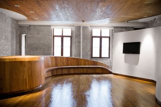 Glossy stained floor and seat with television on wall