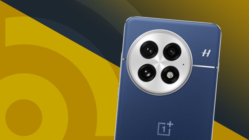 OnePlus 13 in navy blue on a yellow TechRadar logo