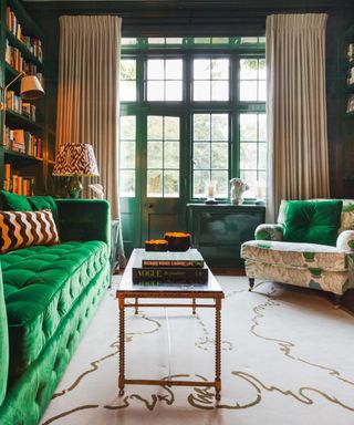 Living room with green button-down sofa and botanical armchair