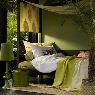 bedroom with green wall and bed with pillows