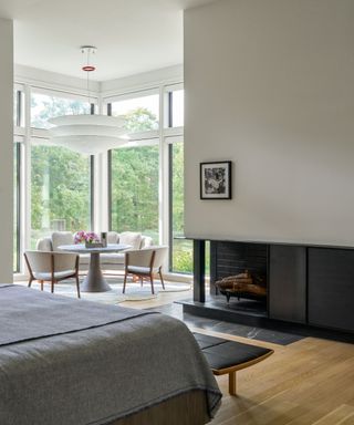 bedroom with fireplace and table in window