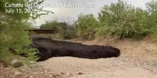 A screenshot shows the rush of the debris flow down the trail.