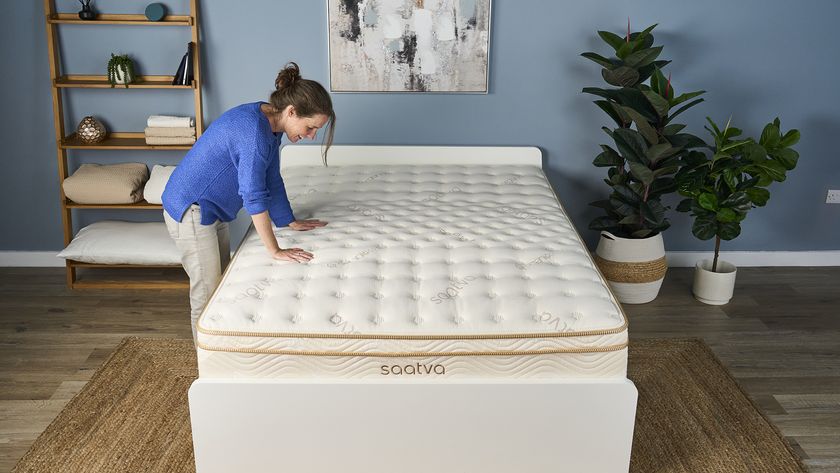 Tom's Guide Mattress Content Director Julia Sagar places both hands on the middle third of the Saatva Classic, where the lumbar crown is located, and smiles because it feels so supportive