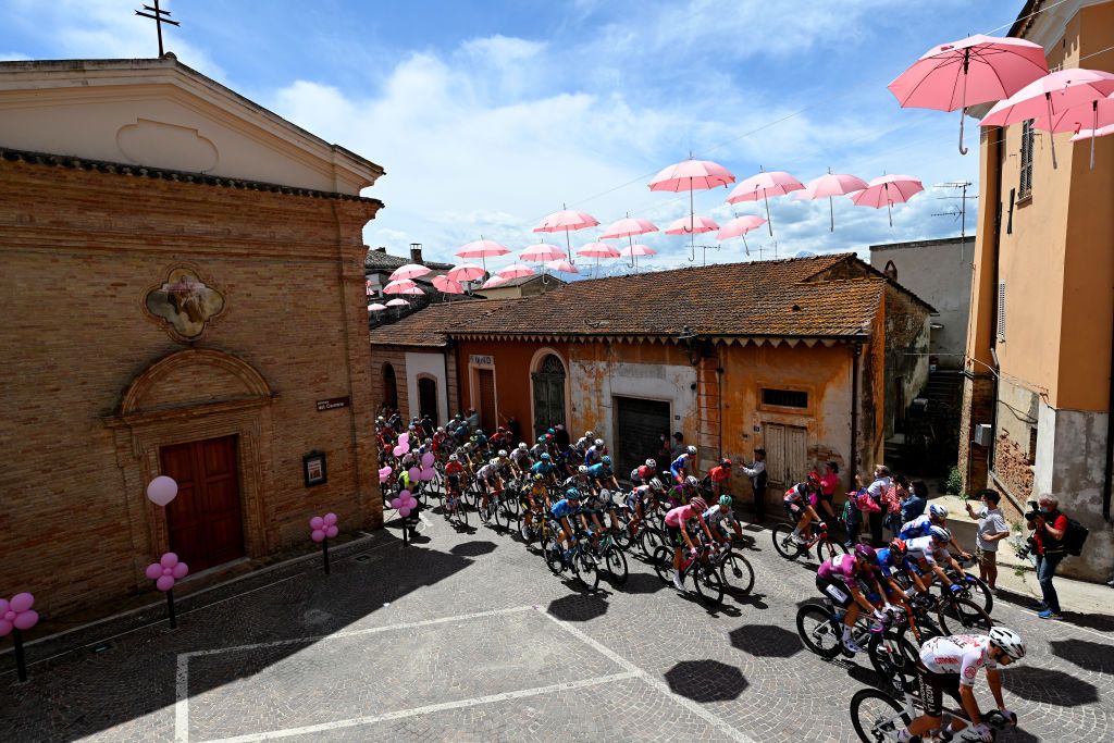 TERMOLI ITALY MAY 14 Giacomo Nizzolo of Italy and Team Qhubeka Assos Purple Points Jersey Attila Valter of Hungary and Team Groupama FDJ Pink Leader Jersey Gino Mader of Switzerland and Team Bahrain Victorious Team Blue Mountain Jersey Remco Evenepoel of Belgium and Team Deceuninck QuickStepWhite Best Young Rider Jersey The Peloton at start in Piazza del Carmine in Notaresco Village during the 104th Giro dItalia 2021 Stage 7 a 181km stage from Notaresco to Termoli Pink Umbrellas girodiitalia Giro on May 14 2021 in Termoli Italy Photo by Stuart FranklinGetty Images