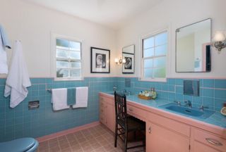A dated pink and blue tiled bathroom
