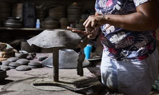 Artisan at work on black clay lampshade by Ames