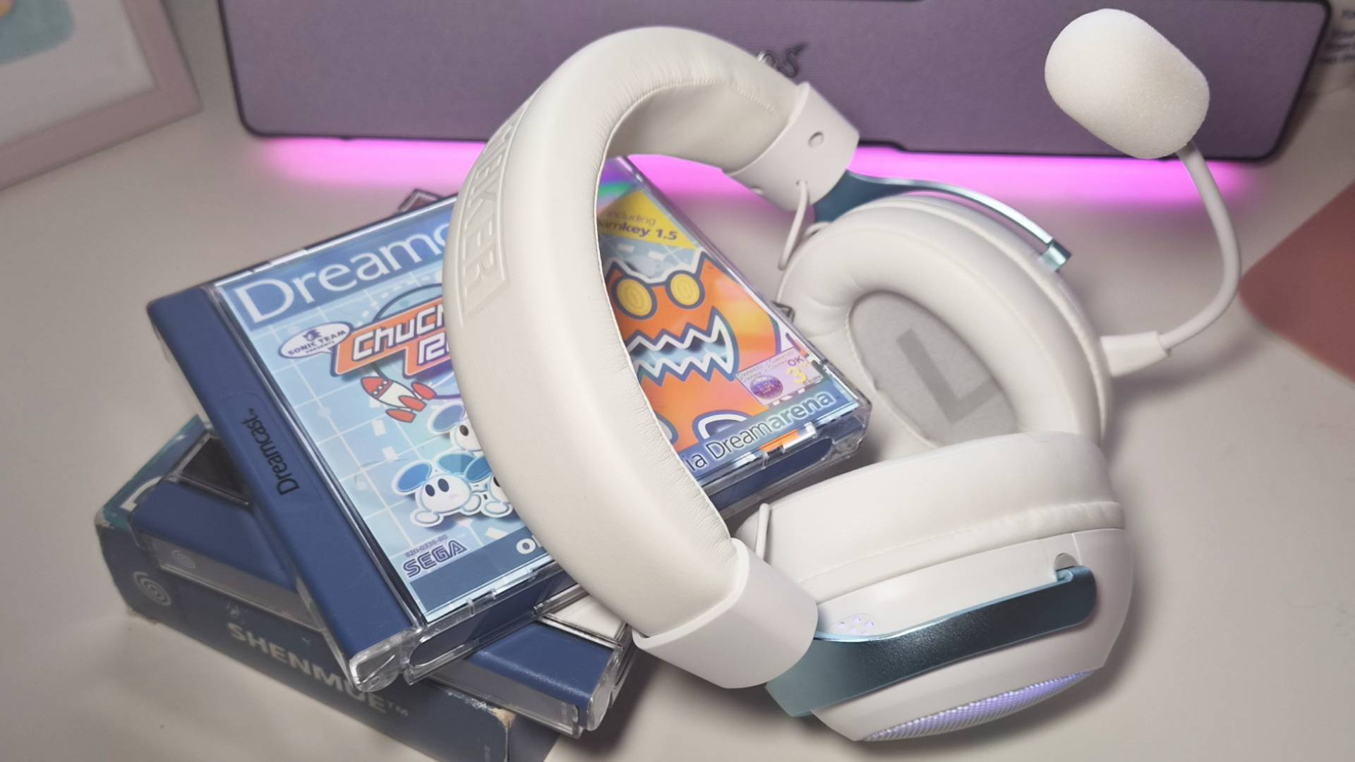 Photo of the white Epomaker GX1 gaming headset sitting on a pile of Dreamcast games.