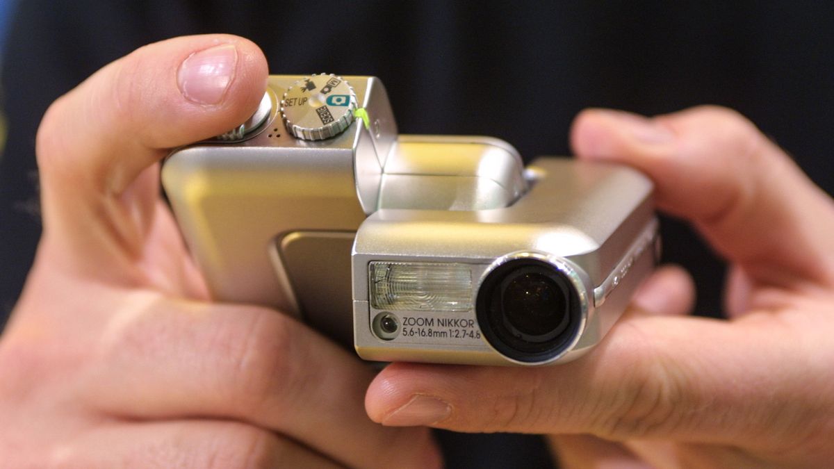 The Nikon Coolpix SQ folding compact camera in a person&#039;s hands