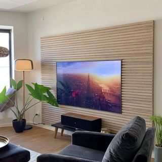 living room with a tv on a wood paneled wall