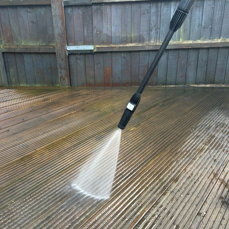 Pressure washer in use cleaning decking