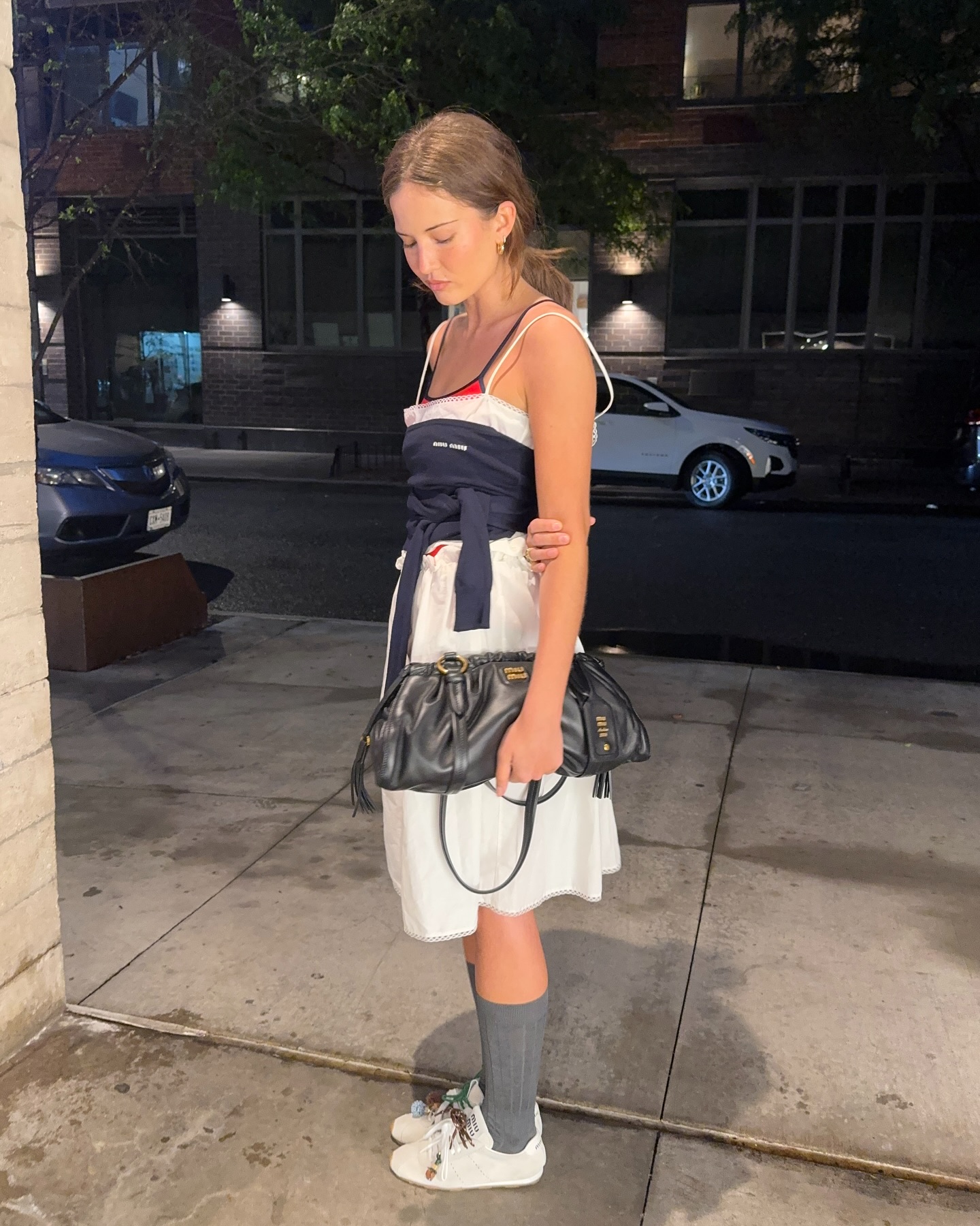 Woman in white skirt, tank tops, and sneakers