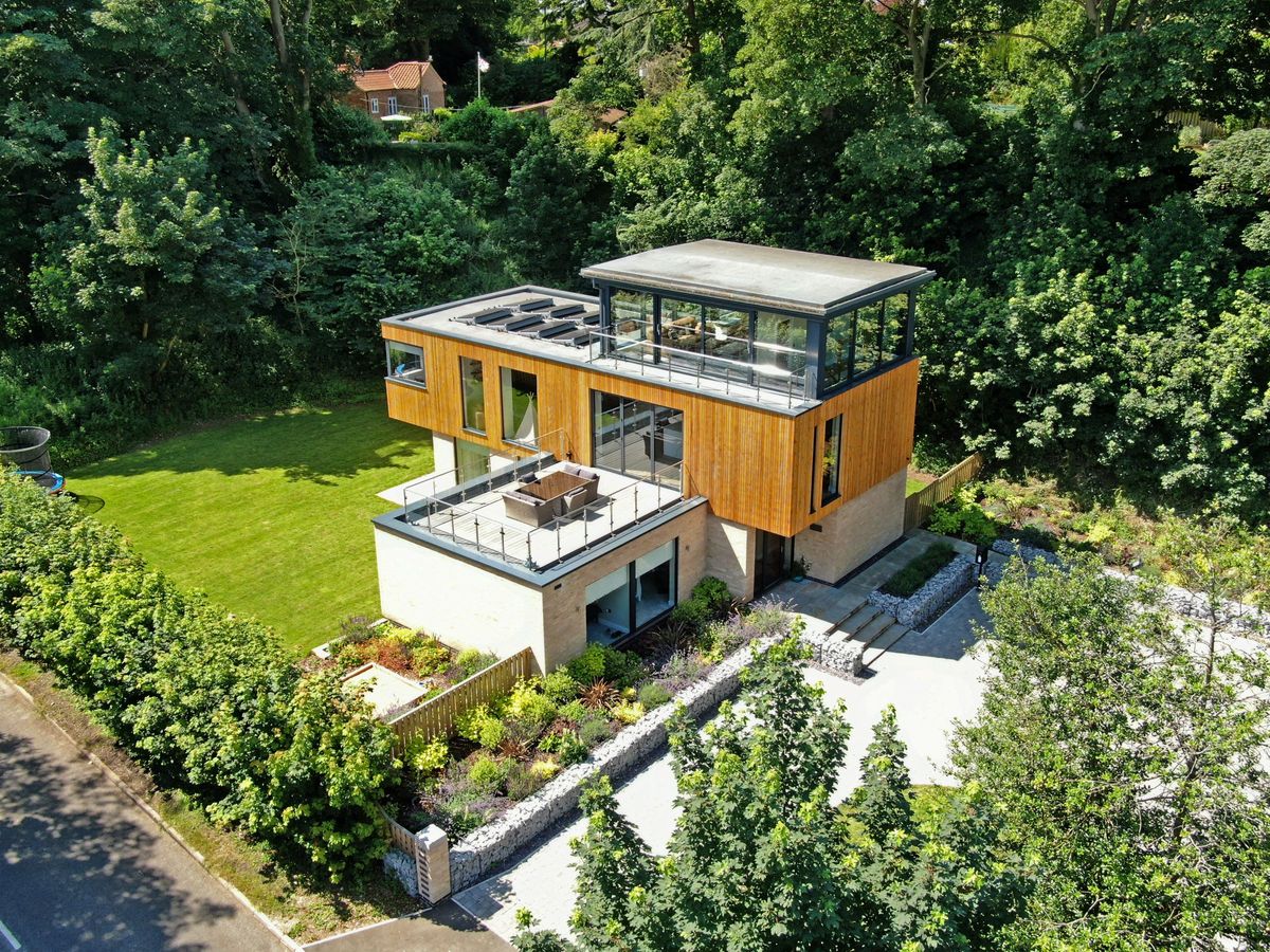An overhead shot of the Glasshouse shows a balcony and solar panels on the roof