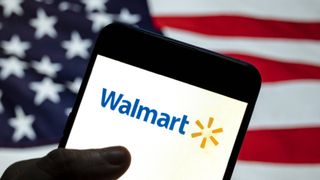 Walmart Presidents Day sale 2024 man holding phone with Walmart logo, US flag in the background