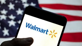 Walmart Memorial Day Sale 2024 man holding phone with Walmart logo, US flag in the background