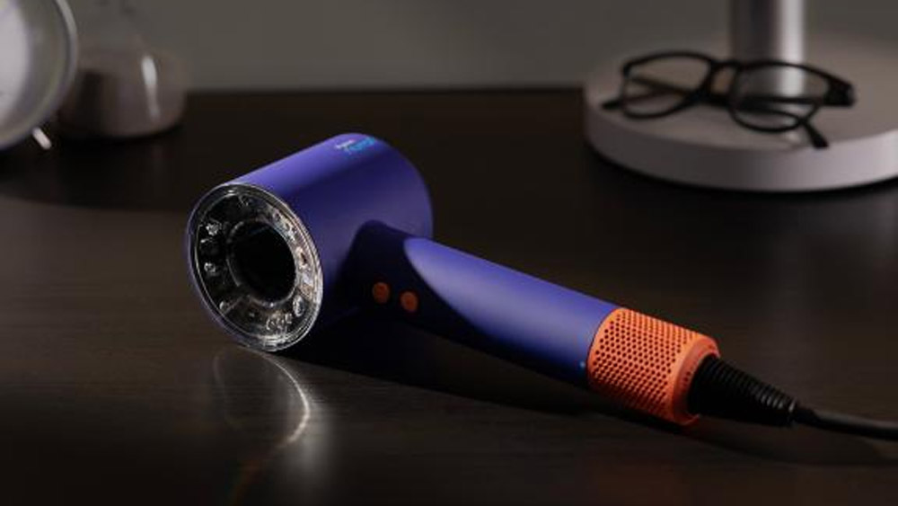 Dyson Supersonic Nural hair dryer in Blue Topaz, lying on a table.