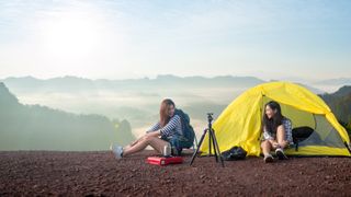 best 2-person tent: A pair of campers sitting outside a 2-person tent