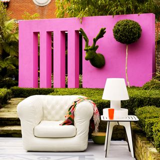 urban garden with brick and pink wall and couch