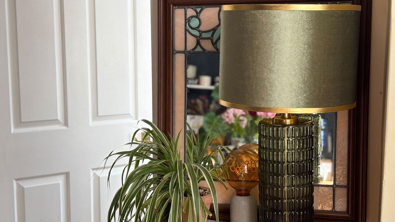 Green lamp infront of mirror with houseplant