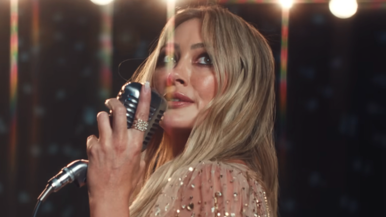 Hilary Duff with a microphone in Mature music video