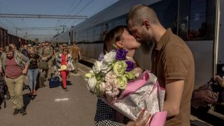 A Ukrainian serviceman kisses his wife, who arrived on a train from Kyiv to visit him, in Kramatorsk, a city in the Donetsk region
