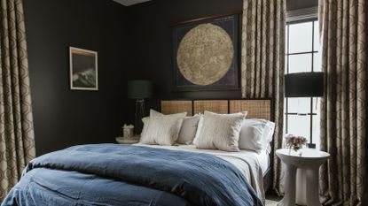 dark grey small bedroom with wicker bed and navy bedding