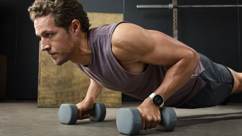 A photo of the Garmin Venu 4 on a man&#039;s wrist as he does weighted push-ups.