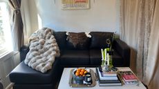 Lola throw blanket draped over a mid-century-style sofa inside of a sunlit NYC living room