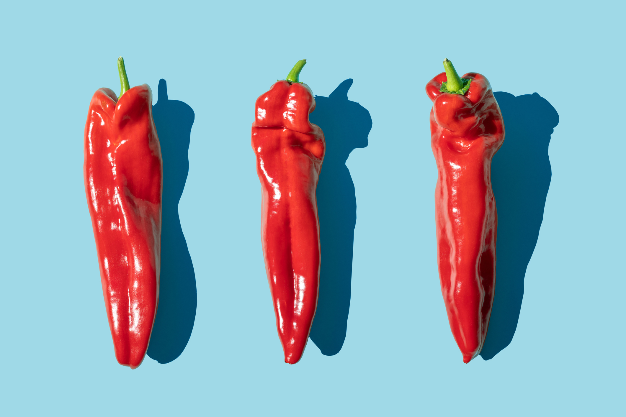 3 chillies (one of the best fat burning foods) on a blue background