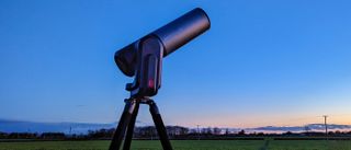 Telescope in-use against night sky near sunset