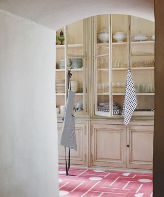 Cabinet with glassware and crockery through an arched doorway