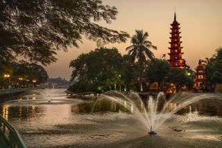 Water fountains spray in the lake in front of Tran Quoc, the oldest Buddhist temple in Hanoi