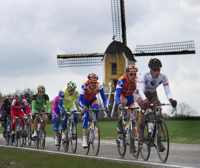 Riders pass by an iconic Dutch windmill