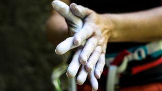 Closeup of a climber applying chalk to their hands