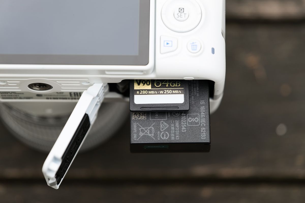 Closeup of the Canon EOS Rebel SL3 / EOS 250D's battery on a bamboo surface
