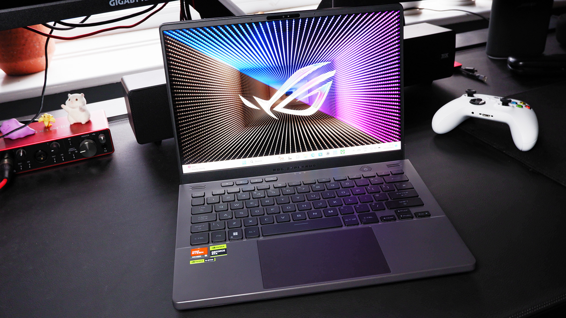 Asus Zephyrus G14 (2023) on a desktop with the Asus default background on-screen