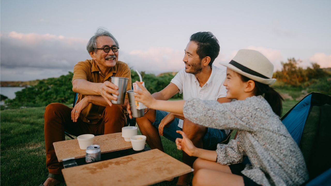 A dad, son and granddaughter share a toast with their individual beverages.