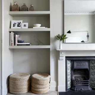 grey living room with float shelves in the alcove and 2 seagrass baskets