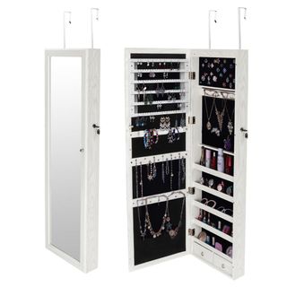 A white mirrored cabinet hangs from a door, and is full of jewelry