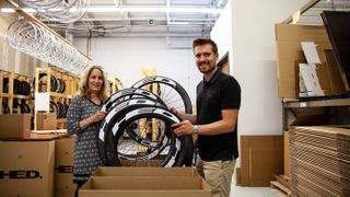 Anne Hed and her son Andrew holding up some carbon wheels