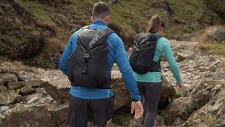 Man and woman wearing Inov-8 hiking clothing and backpacks