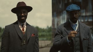 Michael B. Jordan in a red hat and standing next to Michael B. Jordan in a blue hat in Sinners