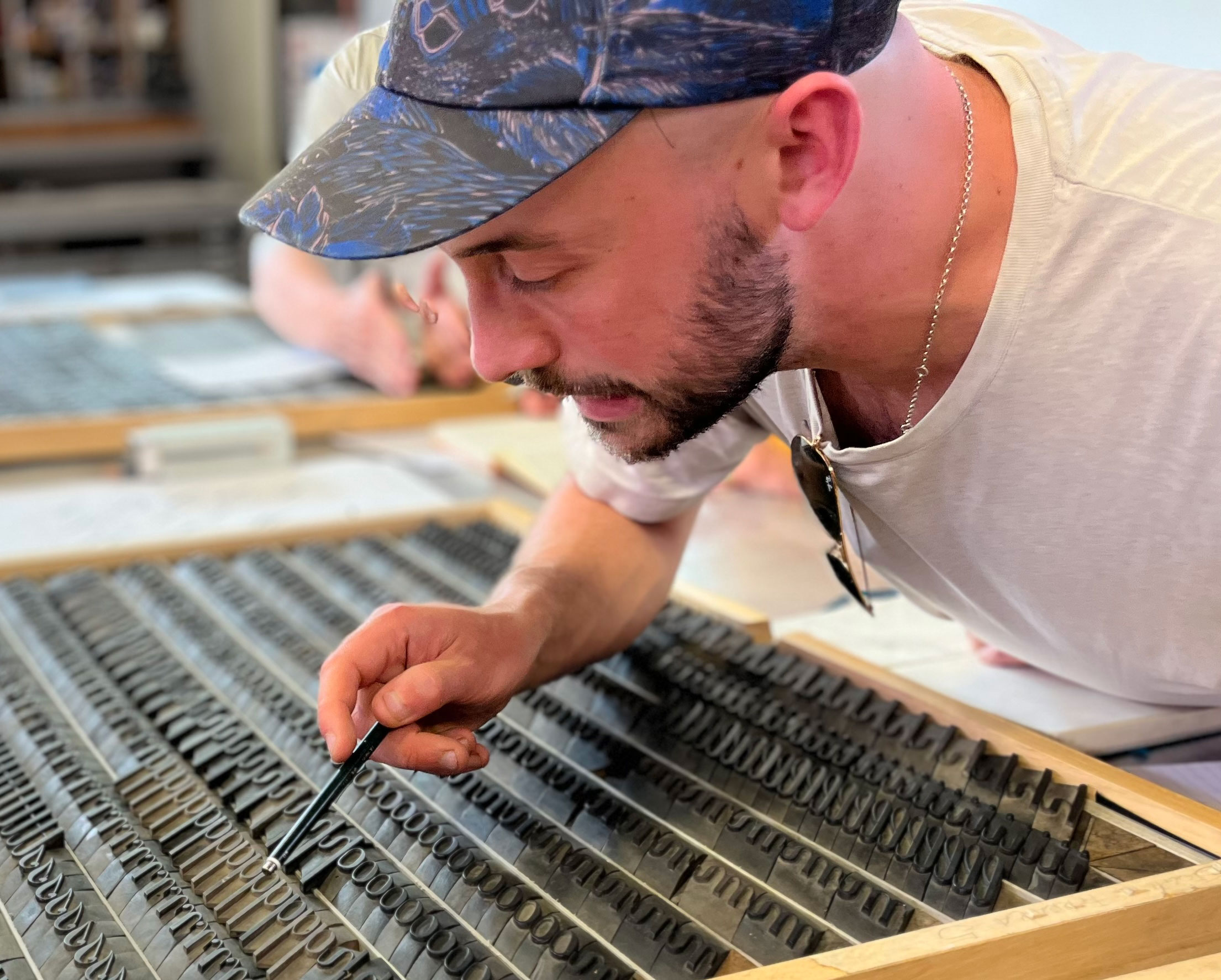 man leaning over typography tool